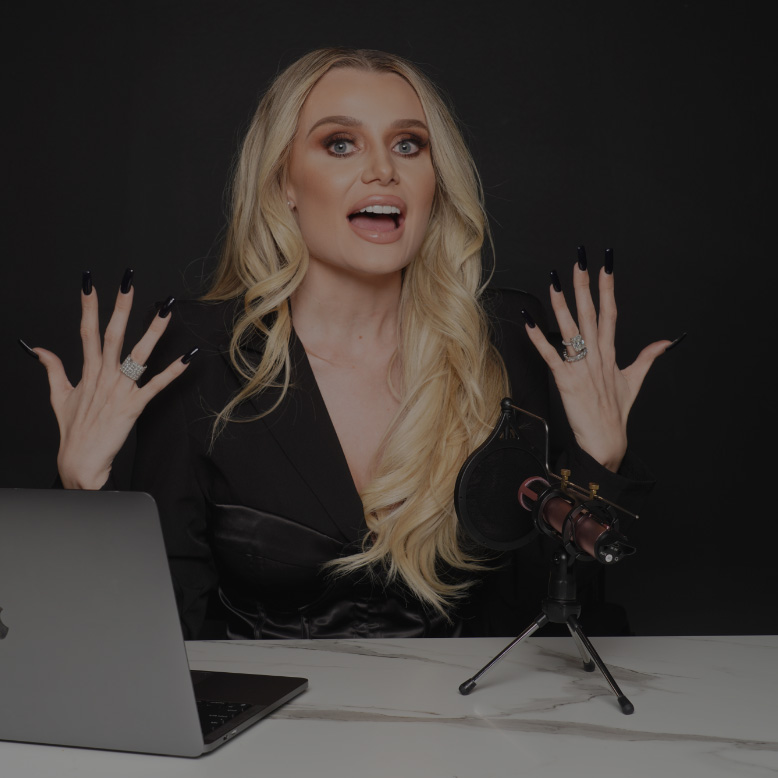 Natalie Dawson sitting at her desk recording a podcast with her hands held up
